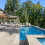 Luxury,Home,Exterior,And,Pool,On,Sunny,Day,With,Blue