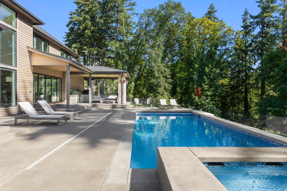 Luxury,Home,Exterior,And,Pool,On,Sunny,Day,With,Blue